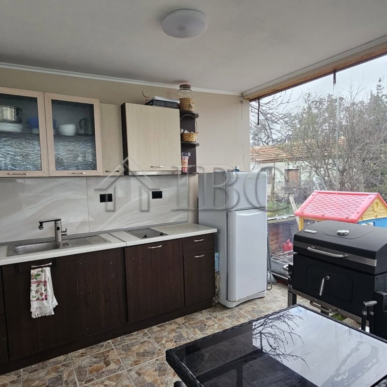 Bright kitchen with garden view and outdoor barbecue area for relaxing meals.
