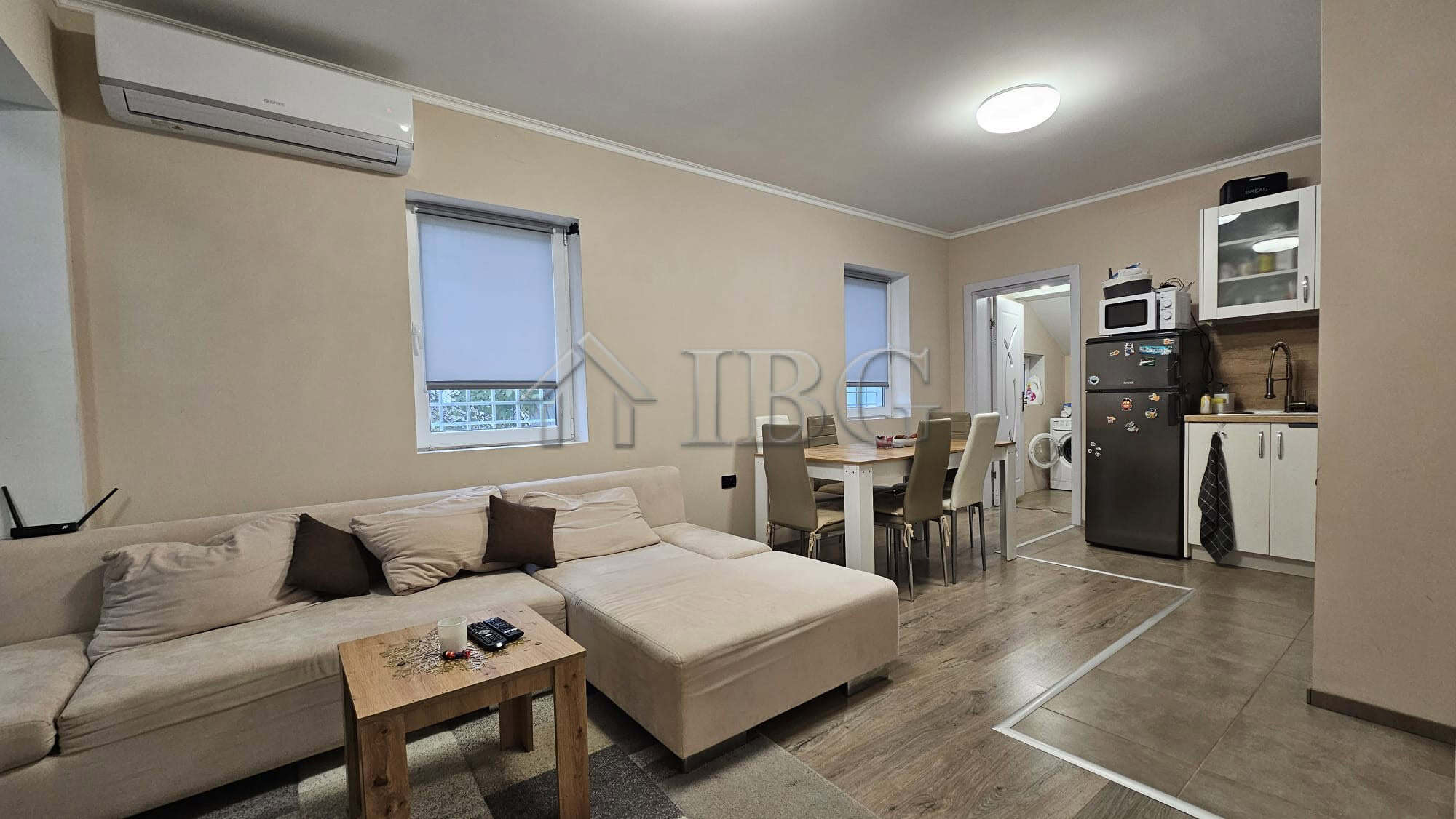 Spacious living room featuring a comfortable sofa, dining table, and open kitchen setup.