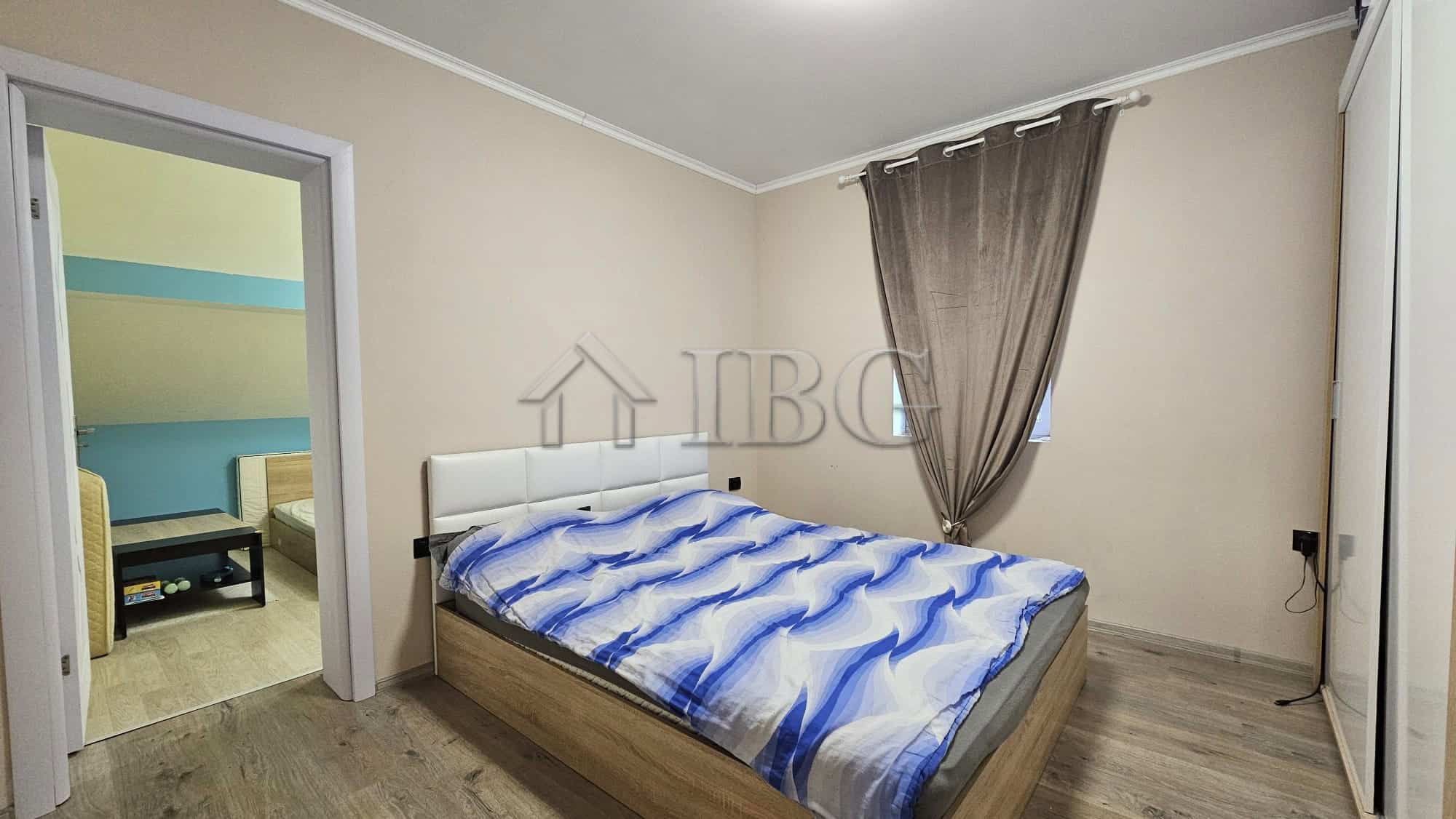 Spacious bedroom with modern decor, adjacent to a second bedroom, in a home near the sea.