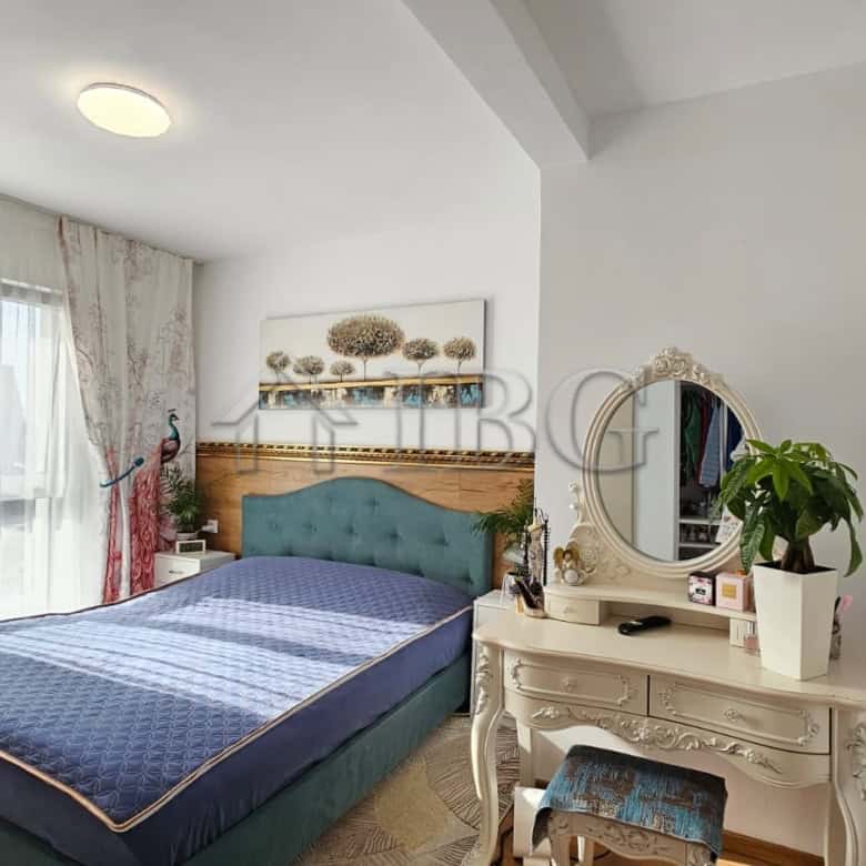 Bright bedroom with large window, blue bed, and elegant white furniture in renovated house.