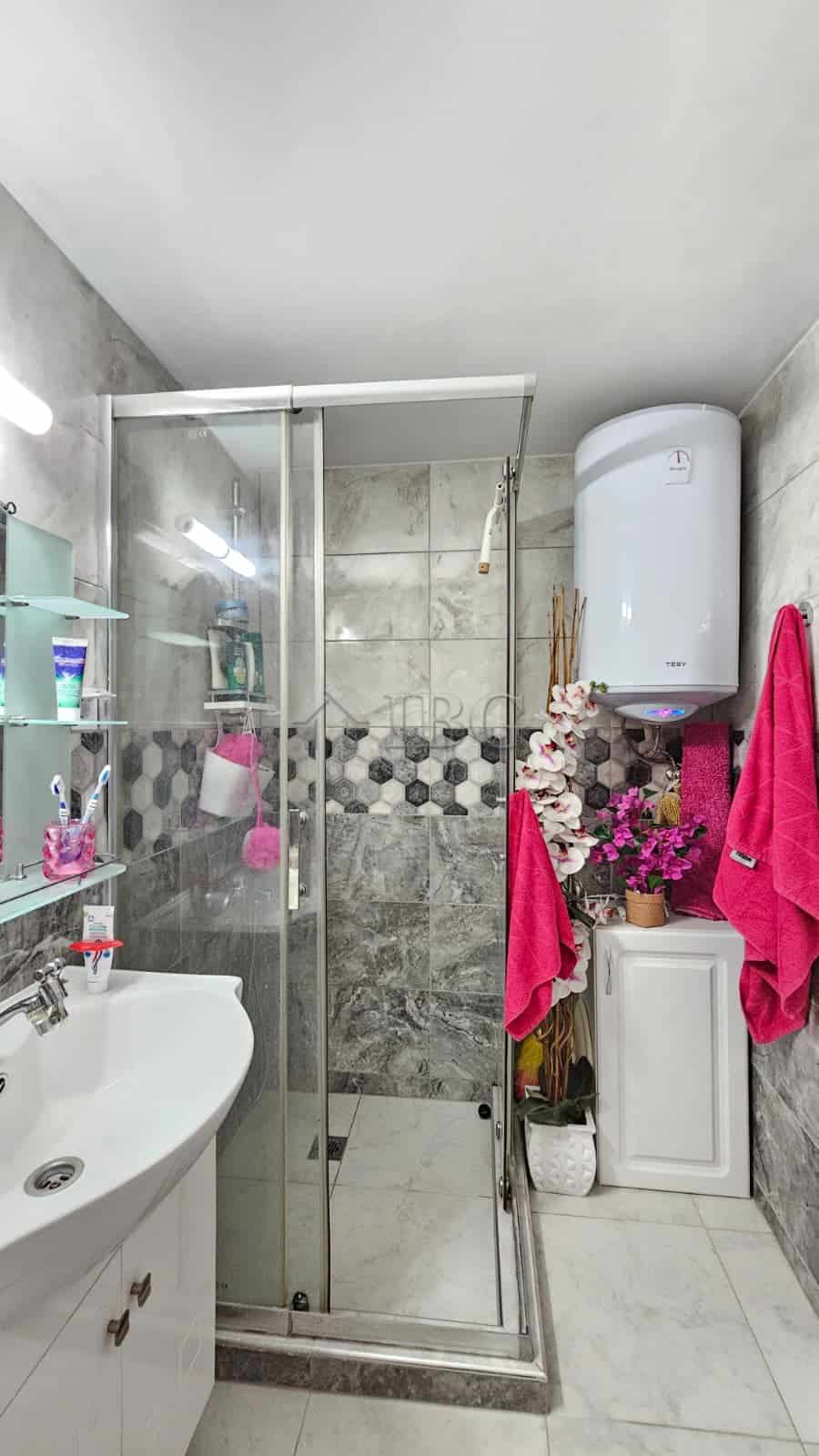 Bright bathroom with glass shower enclosure and contemporary fixtures.