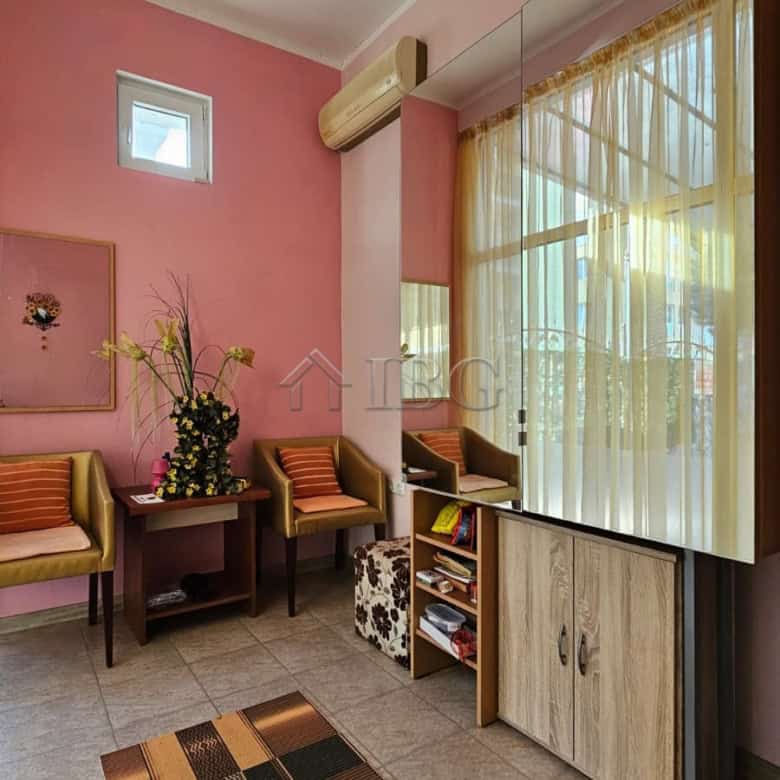 Interior view of a commercial property in Sunny Beach, featuring pink walls, seating area, and large.