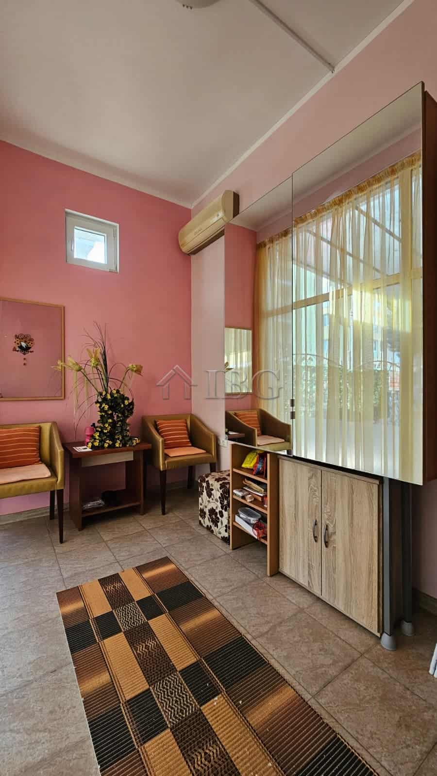 Interior view of a commercial property in Sunny Beach, featuring pink walls, seating area, and large.