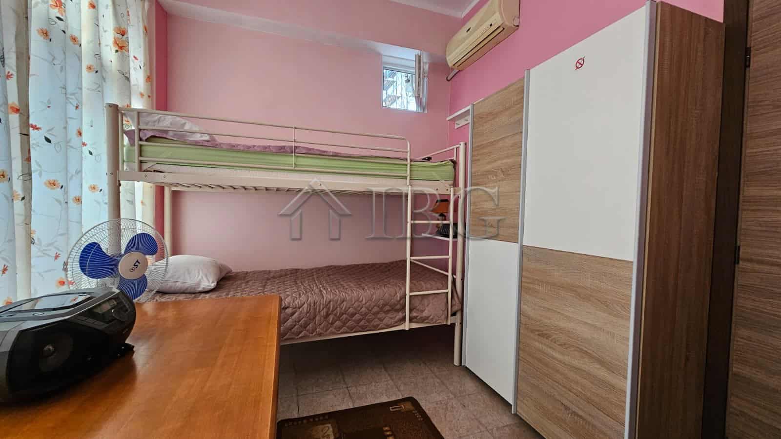 Cozy bedroom featuring a bunk bed, wardrobe, and air conditioning unit in a sunny beach area.