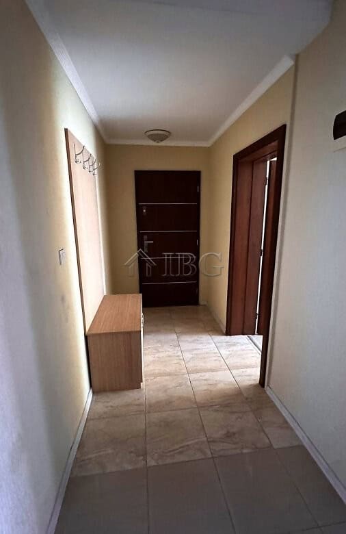 Interior view of a hallway in a 2-bedroom apartment with tiled flooring and wooden doors in Sunny Be.