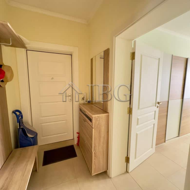Spacious hallway featuring a shoe rack, mirror, and seating bench for convenience.