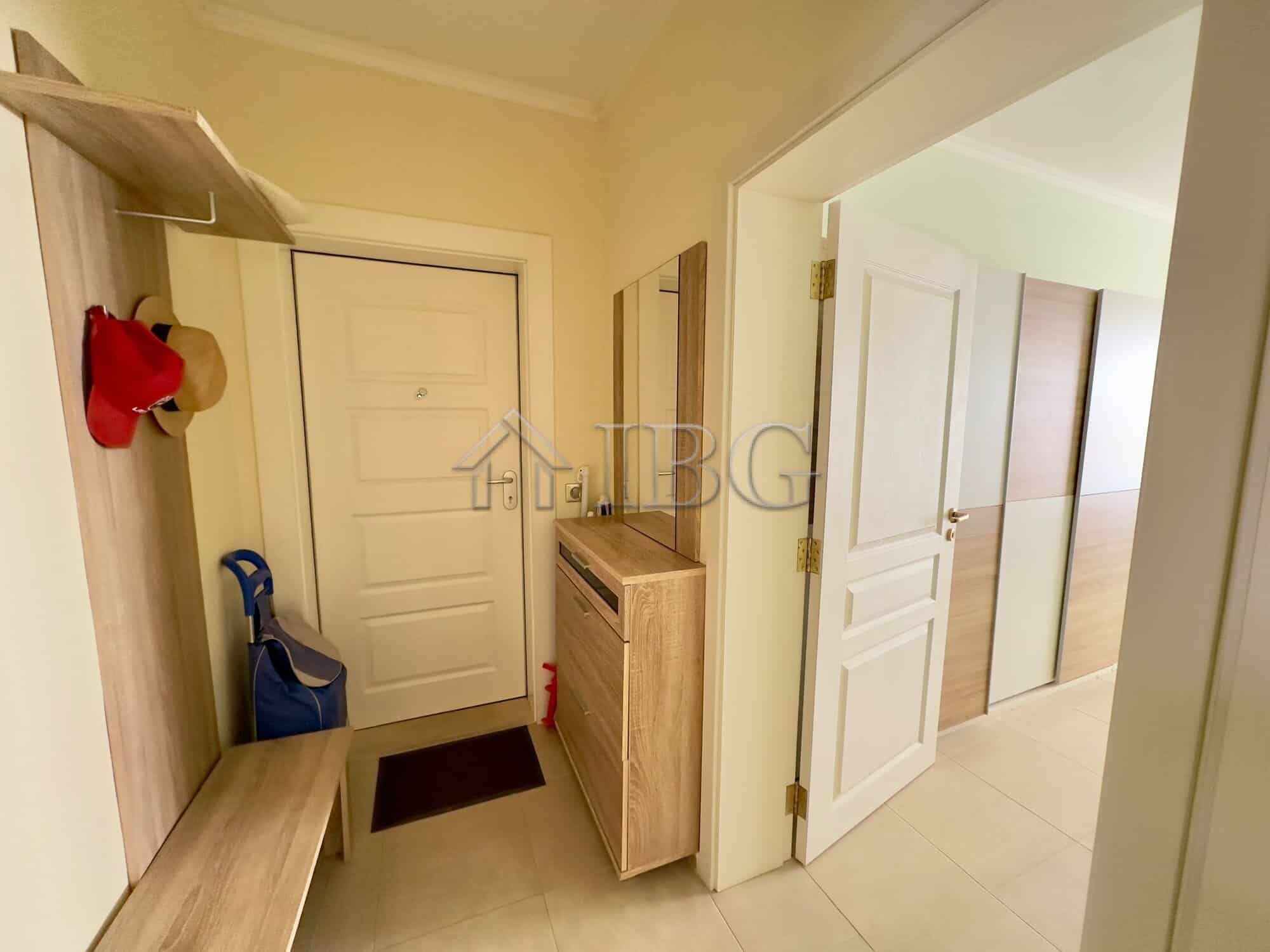 Spacious hallway featuring a shoe rack, mirror, and seating bench for convenience.