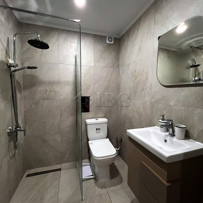 Modern bathroom with shower, toilet, and sink in a contemporary apartment.