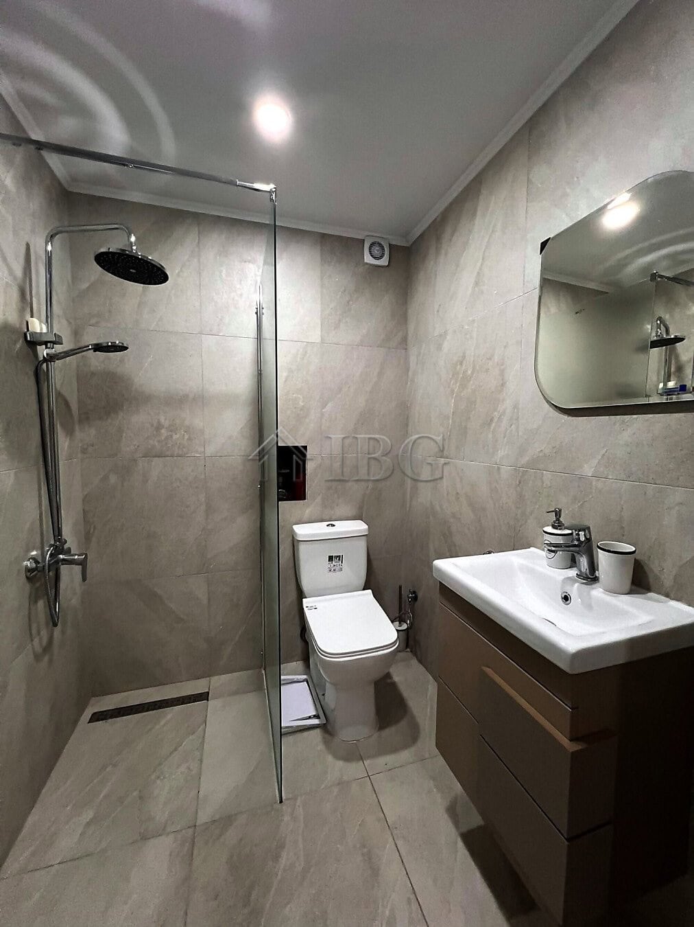 Modern bathroom with shower, toilet, and sink in a contemporary apartment.