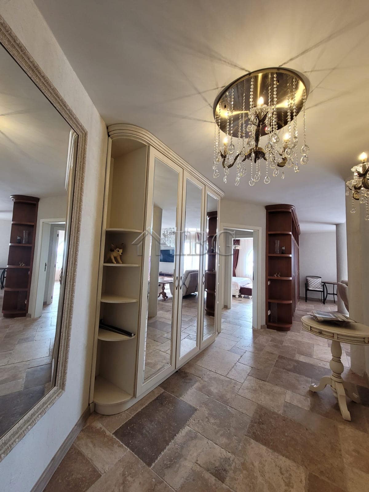 Elegant interior of a three-level maisonette featuring a chandelier and spacious living area.