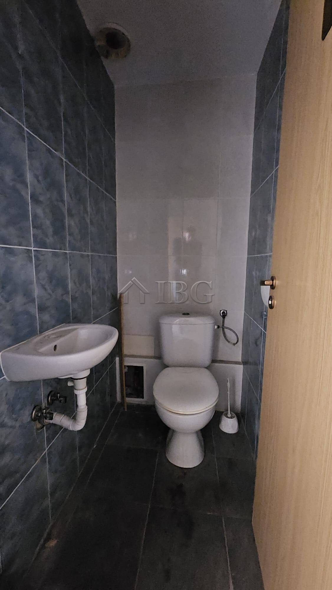 Compact bathroom with toilet and sink in a commercial property on Main Street, Sunny Beach.
