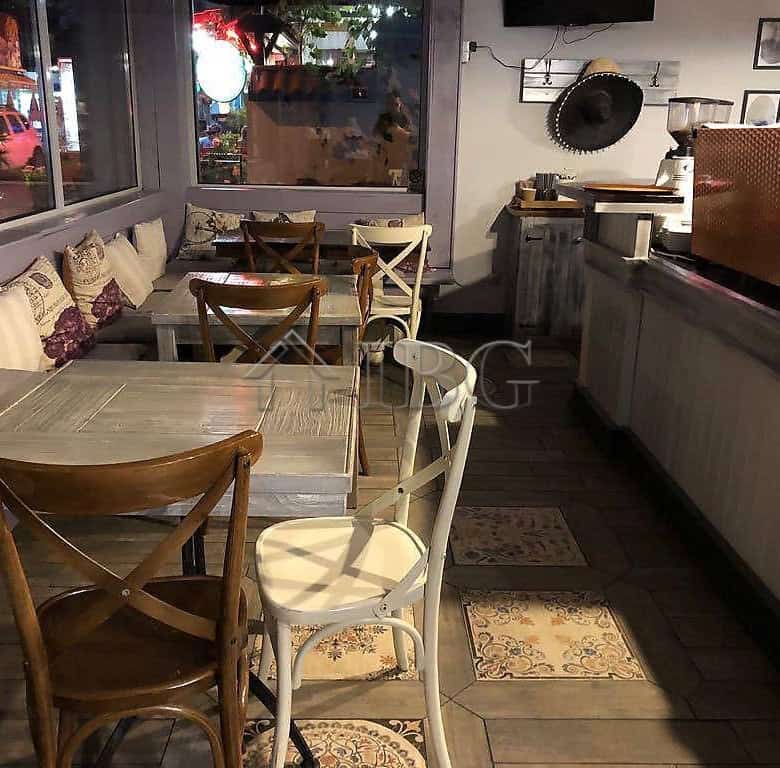 Exclusive restaurant interior in Nessebar with wooden tables and comfortable seating.