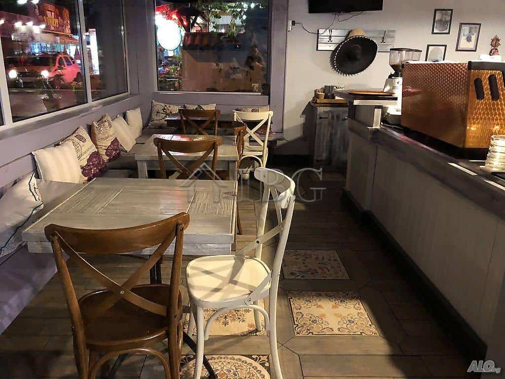 Exclusive restaurant interior in Nessebar with wooden tables and comfortable seating.