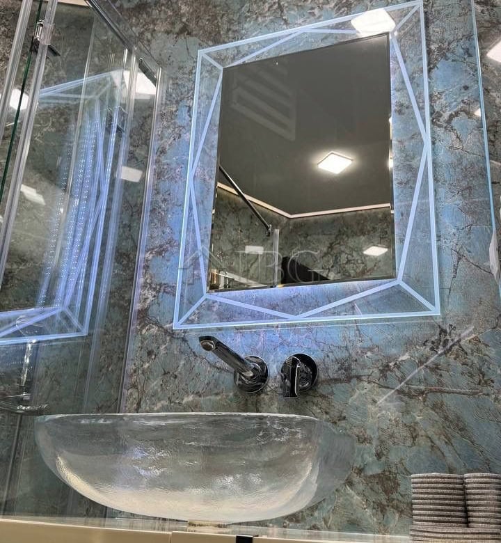 Illuminated mirror with LED lighting in a contemporary bathroom setting.