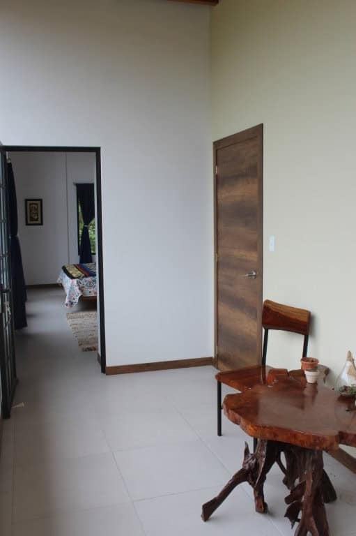 Interior view of a modern Ecuadorian house with wooden accents and minimalist decor.