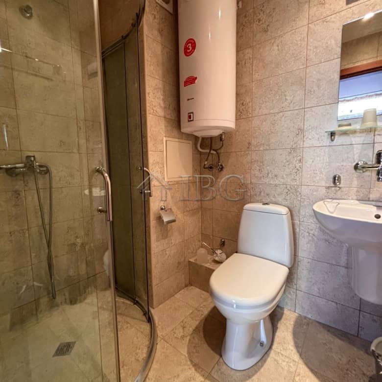 Small bathroom with shower, toilet, and water heater in Dawn Park, Sunny Beach.