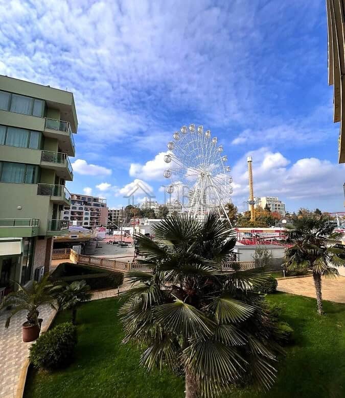 Bright view of Sunny Beach with Ferris wheel and pool area.