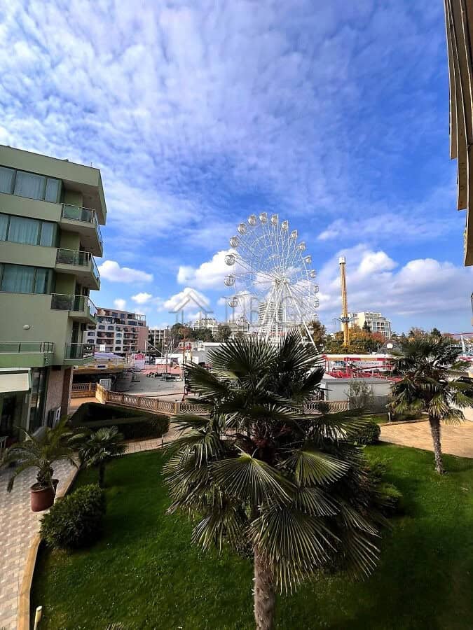 Bright view of Sunny Beach with Ferris wheel and pool area.