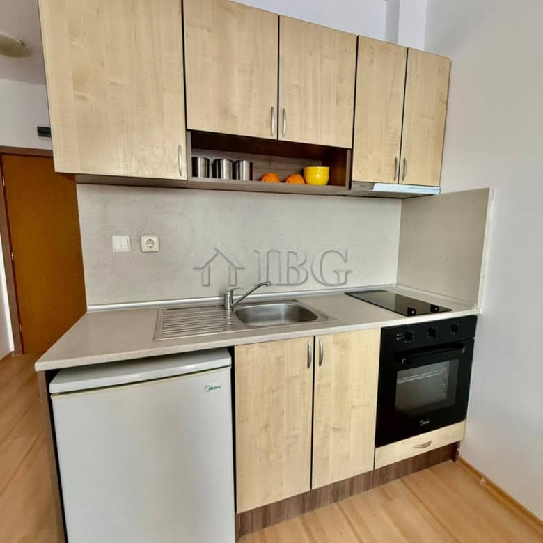 Furnished studio kitchen with modern cabinets, sink, stove, and mini fridge in Sunny Day 3, Sunny Be.