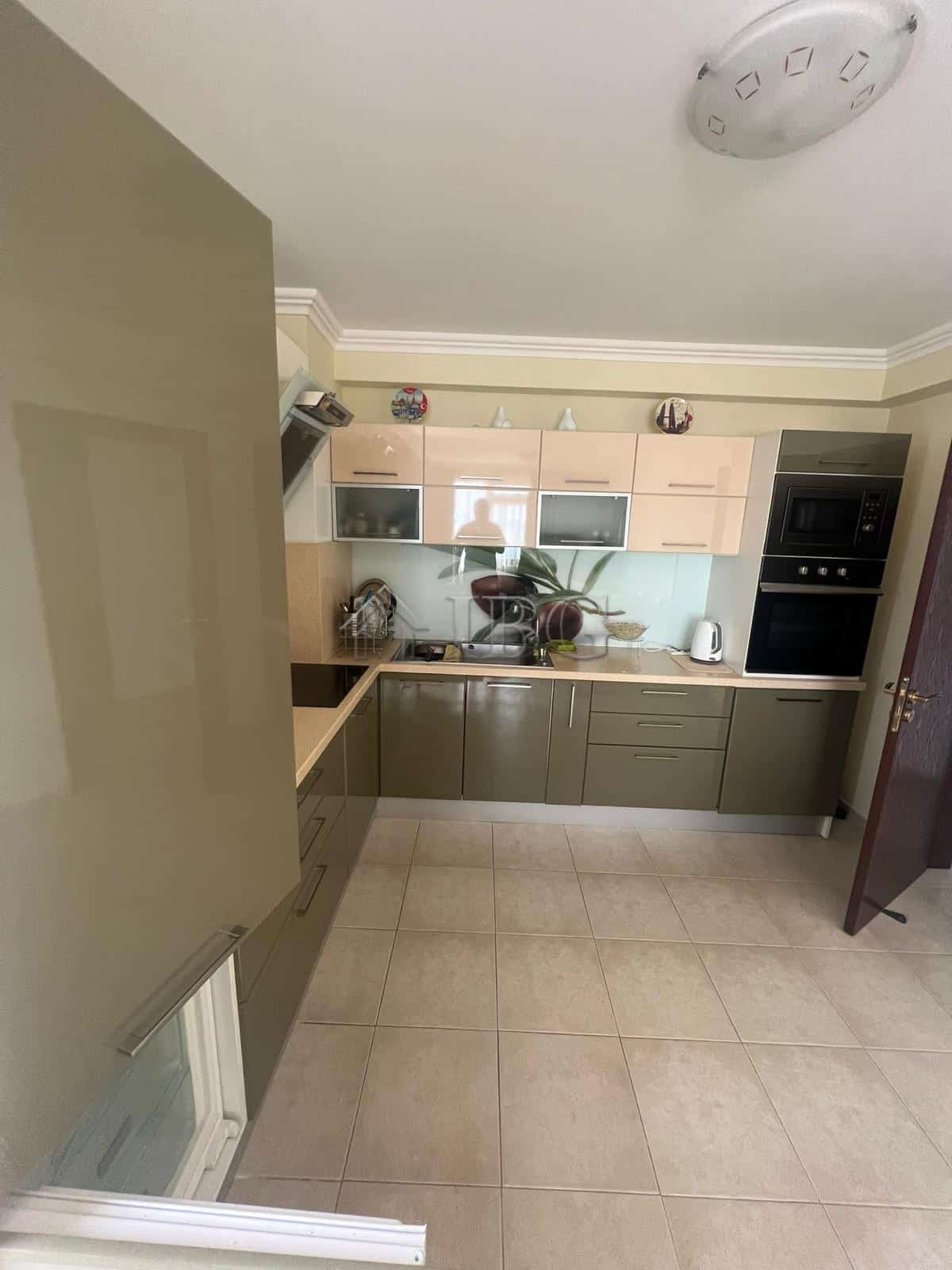Kitchen with beige cabinets and modern appliances in Sveti Vlas.