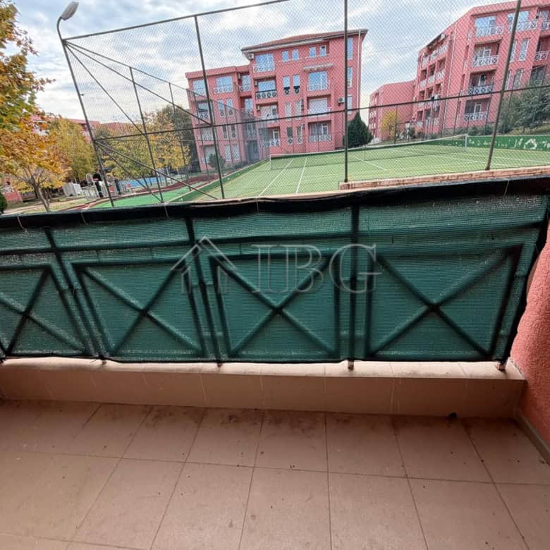 Balcony overlooking a tennis court and park in sunny beach area. Perfect for relaxing and enjoying o.