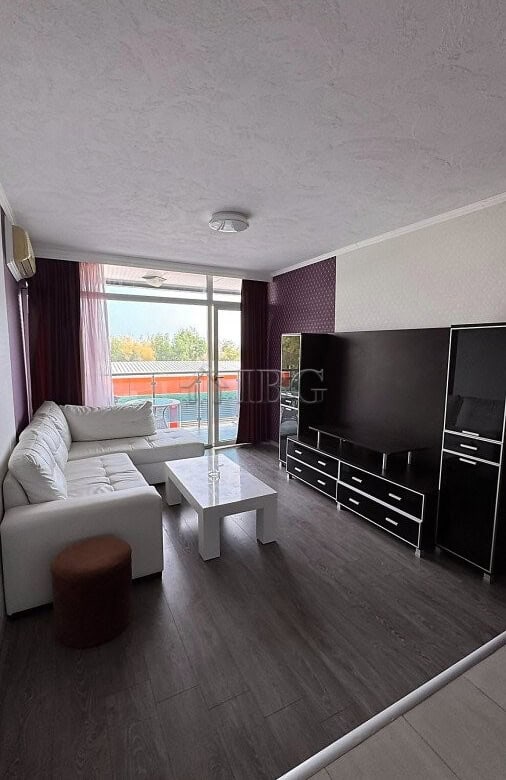 Bright living room with pool and partial sea view in Sunny Beach apartment.