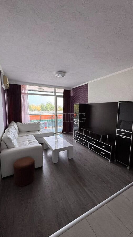 Bright living room with pool and partial sea view in Sunny Beach apartment.