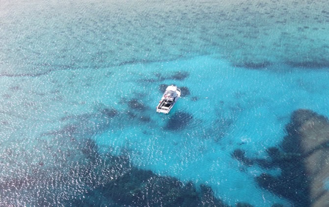 Aerial view of two land plots on Little Cayman surrounded by turquoise waters.