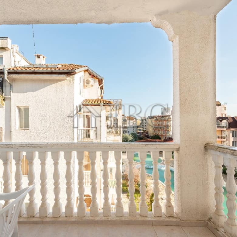 Balcony view of a renovated 2-bedroom apartment overlooking a pool in Sunny Beach.
