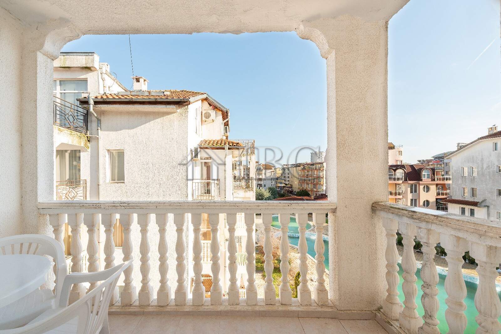 Balcony view of a renovated 2-bedroom apartment overlooking a pool in Sunny Beach.