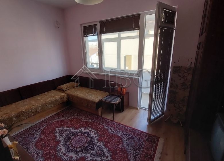 Interior view of a family house living room with a sofa, window, and balcony in Burgas.