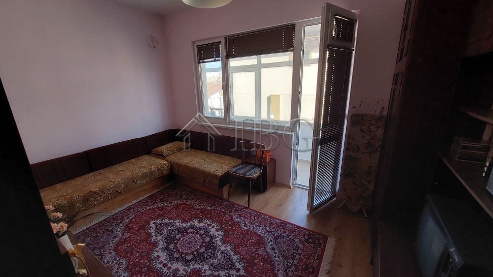 Interior view of a family house living room with a sofa, window, and balcony in Burgas.