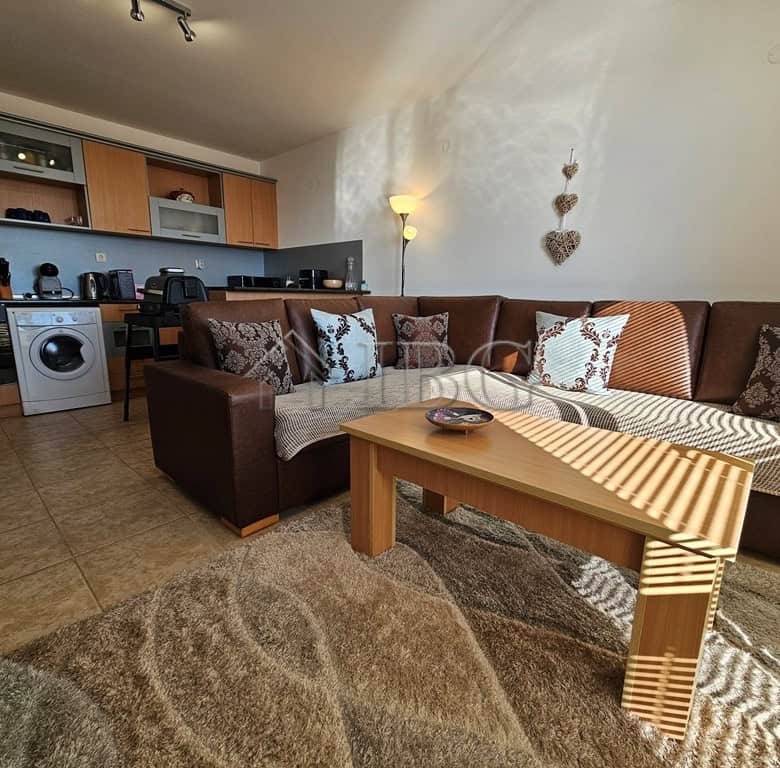 Bright living room with modern open-plan kitchen and comfortable sofa.