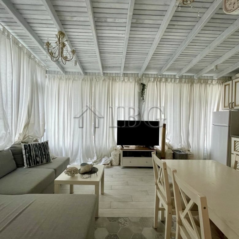 Bright living room with white curtains, sofa, and TV in Sun Gate, Sunny Beach.