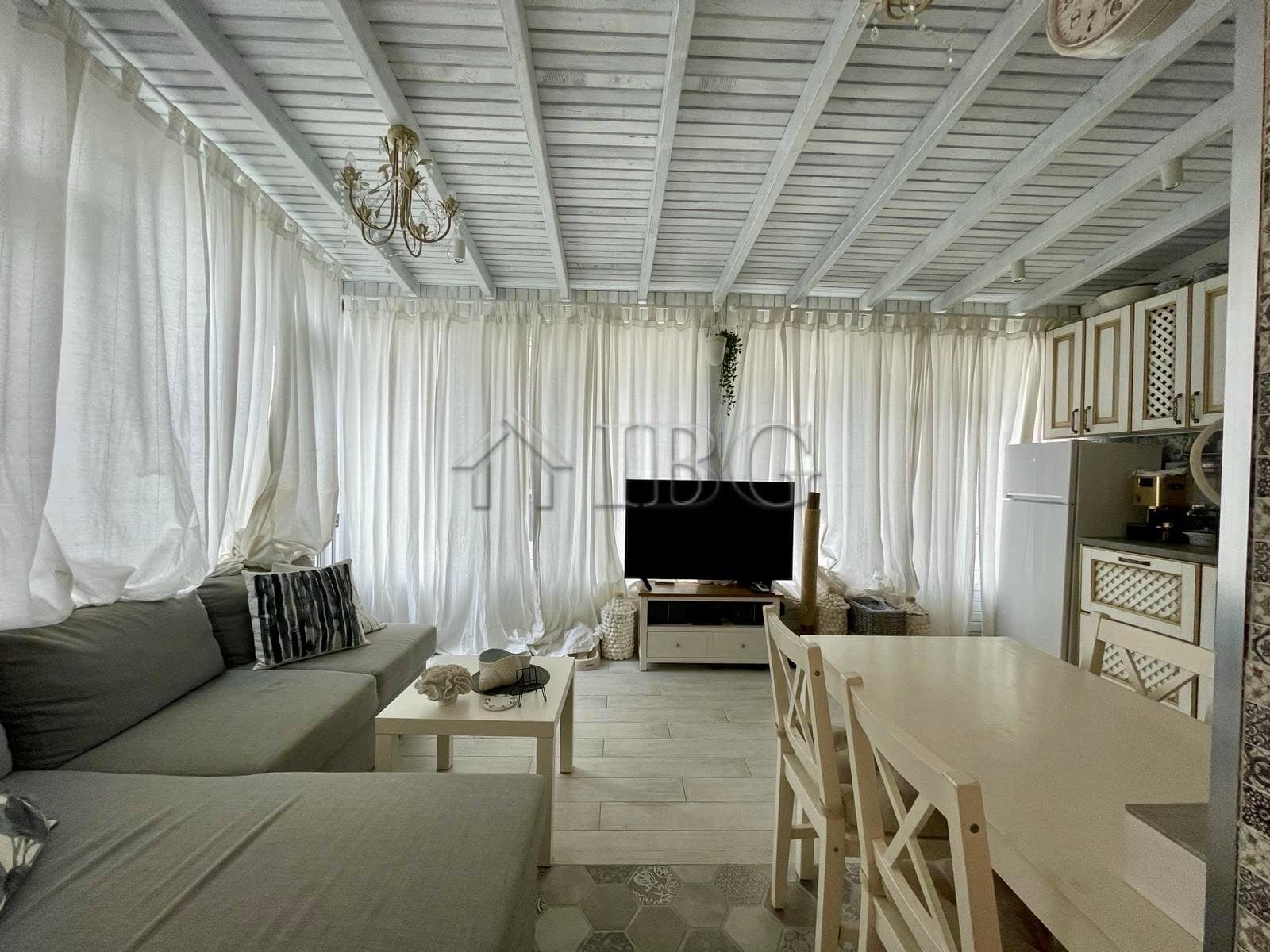 Bright living room with white curtains, sofa, and TV in Sun Gate, Sunny Beach.