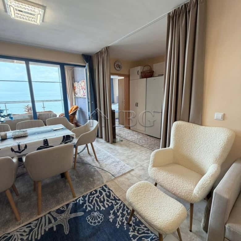 Bright living room with sea view, dining area, and cozy seating in Sunny Beach apartment.