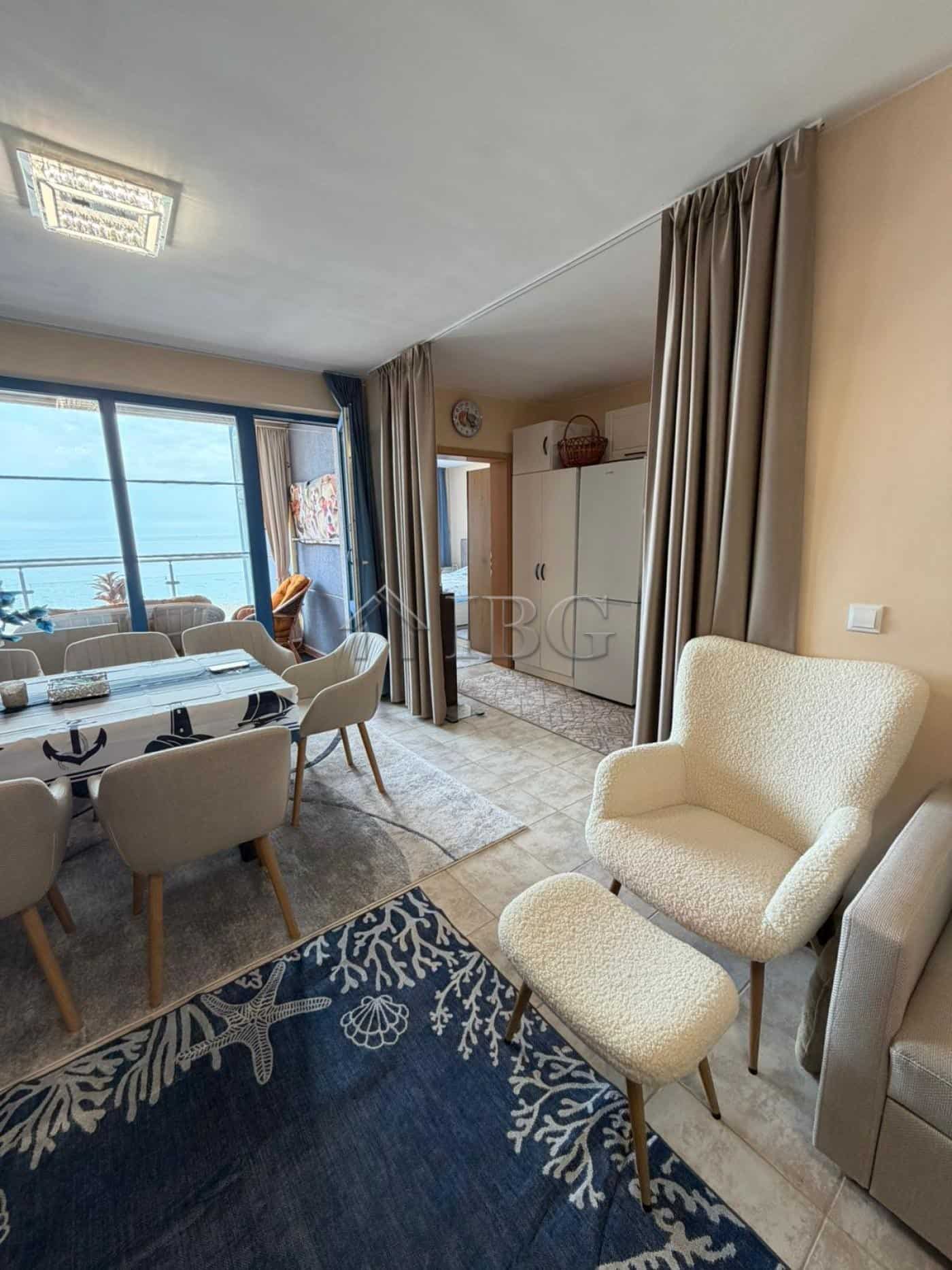 Bright living room with sea view, dining area, and cozy seating in Sunny Beach apartment.