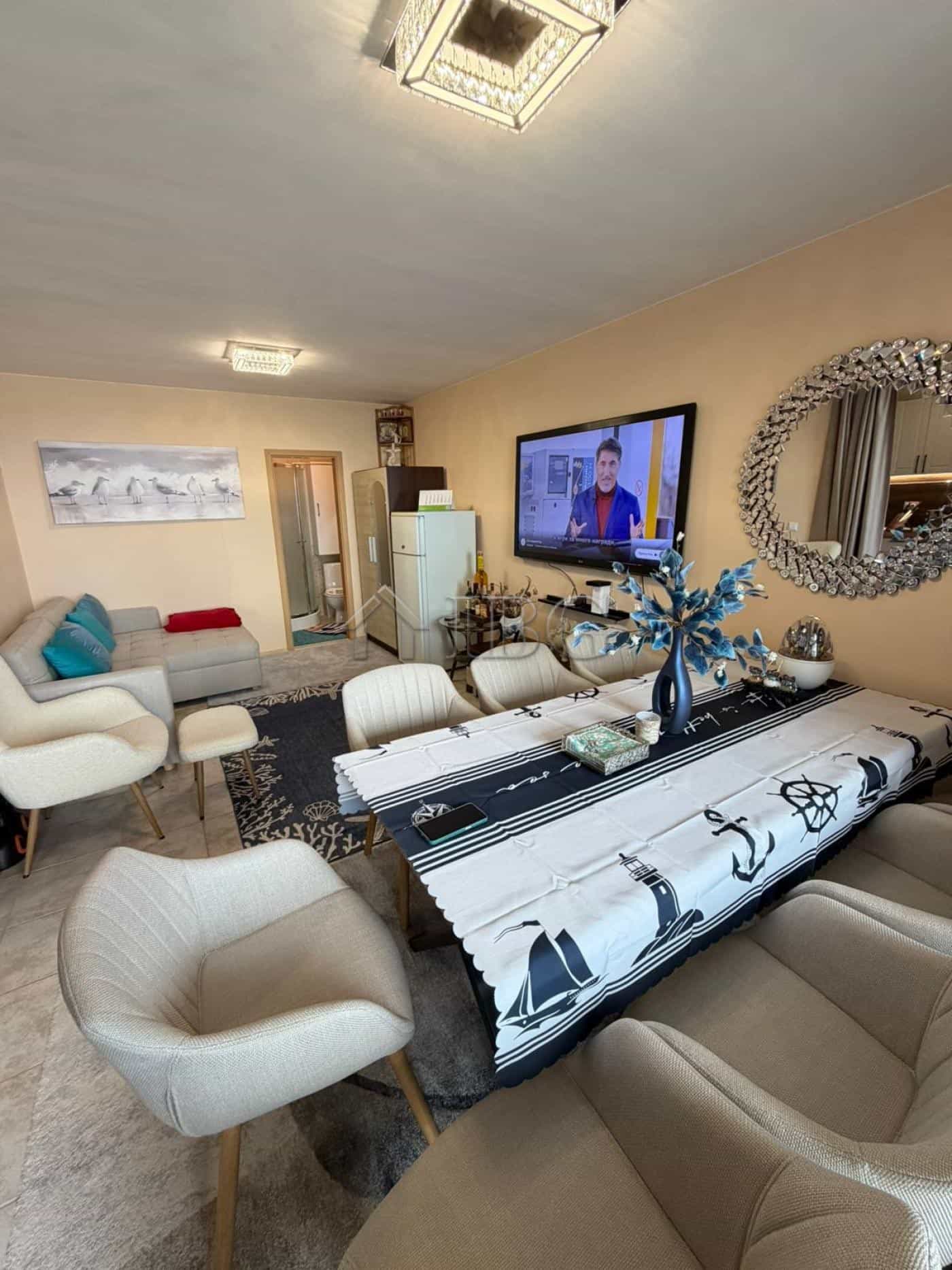 Bright living room with sea view, TV, and stylish furniture in Sunny Beach apartment.