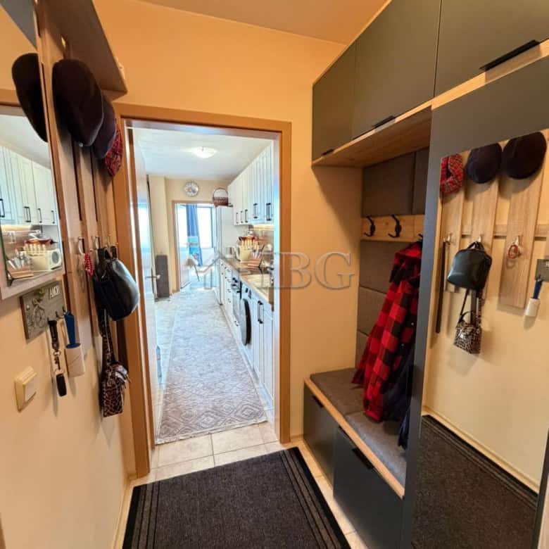 Entrance hall with hooks, shoes, and storage in Sunny Beach apartment.