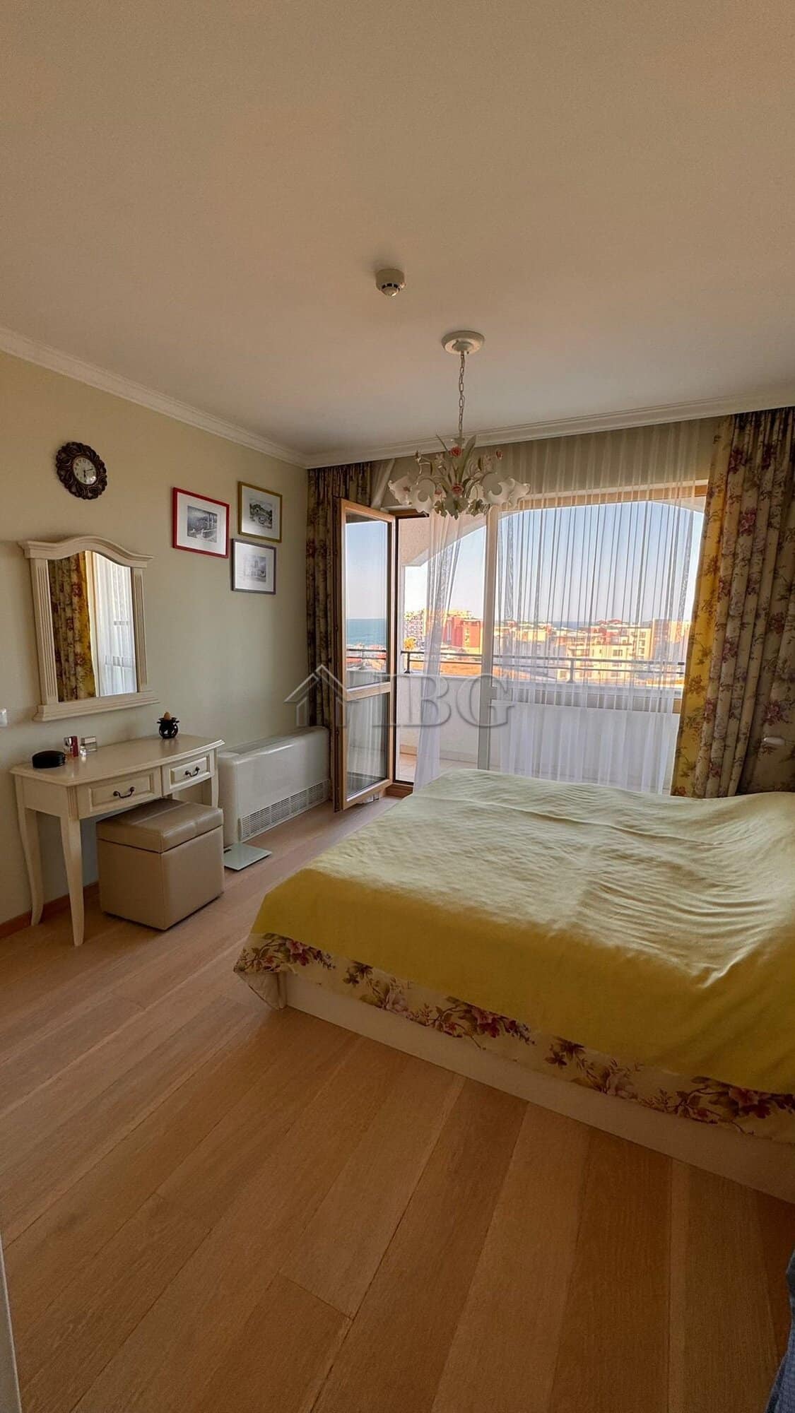 Spacious bedroom with large window offering stunning sea and mountain vistas in Sveti Vlas.