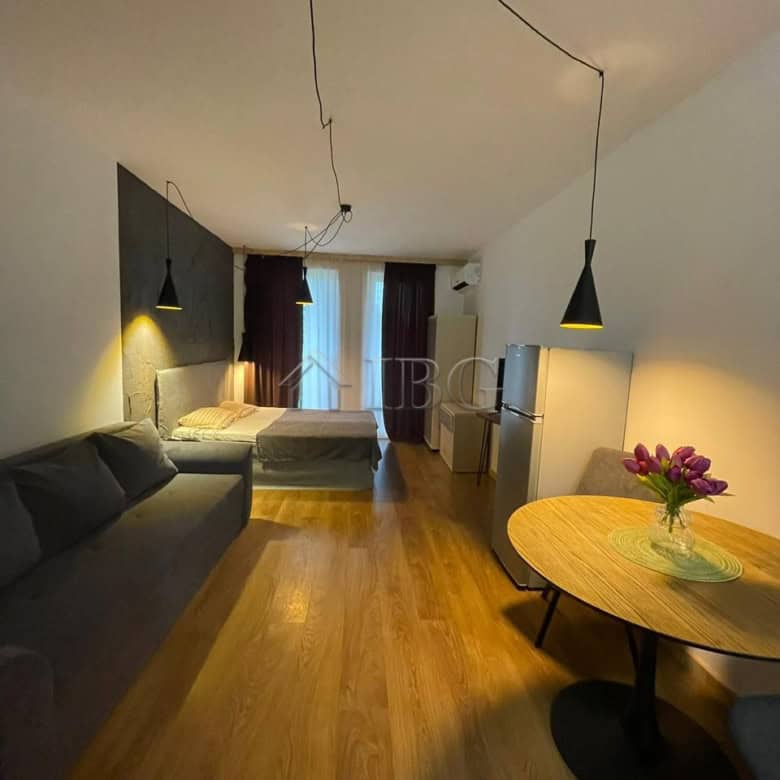 Interior of a studio apartment with a sofa, bed, dining table, and balcony in Sunny View Central, Su.