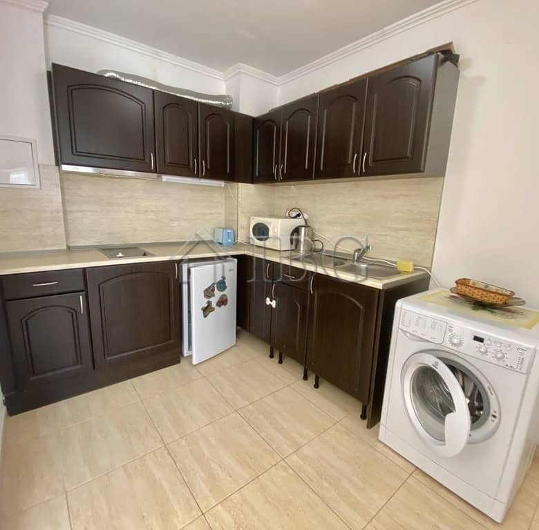 Spacious kitchen featuring dark wood cabinetry, washing machine, and essential appliances in Sveti V.