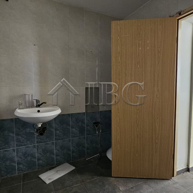 Interior view of a commercial space with a small sink and open door in Sunny Beach.