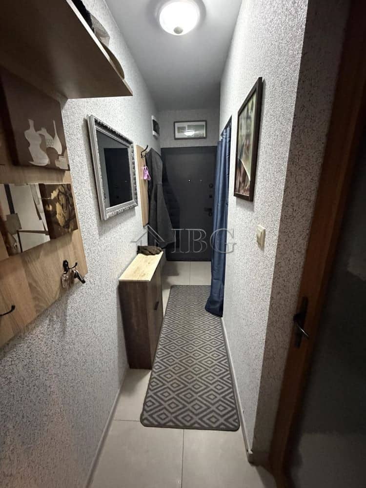 Bright hallway of a new one-bedroom apartment with stylish decor and a view of the large terrace in.