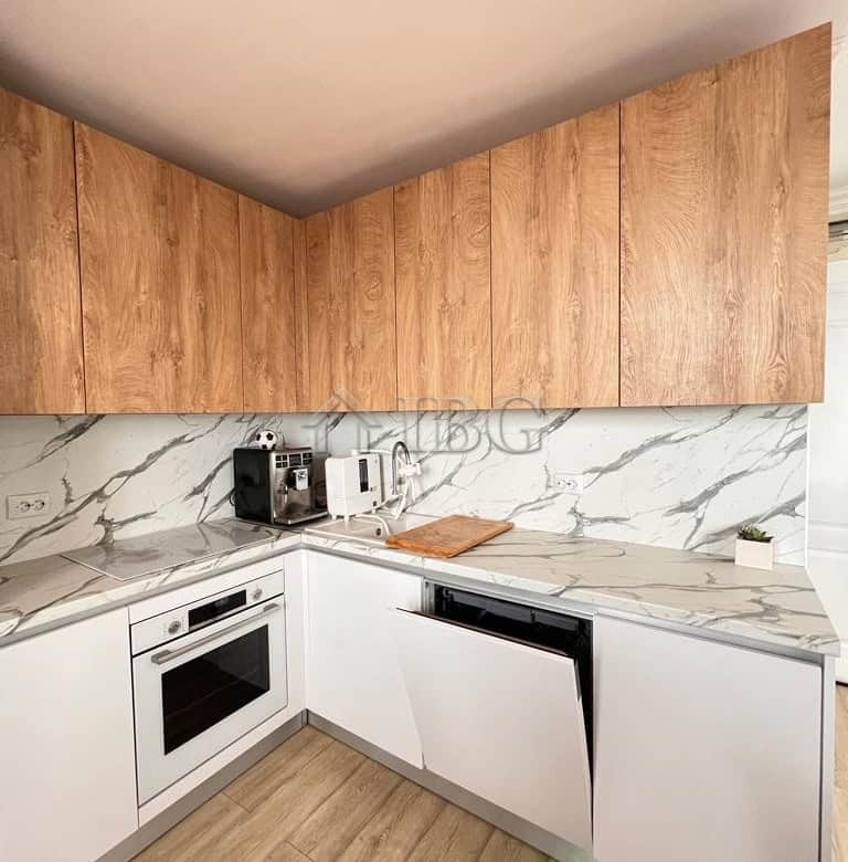 Modern kitchen with wooden cabinets and marble backsplash in Sveti Vlas.