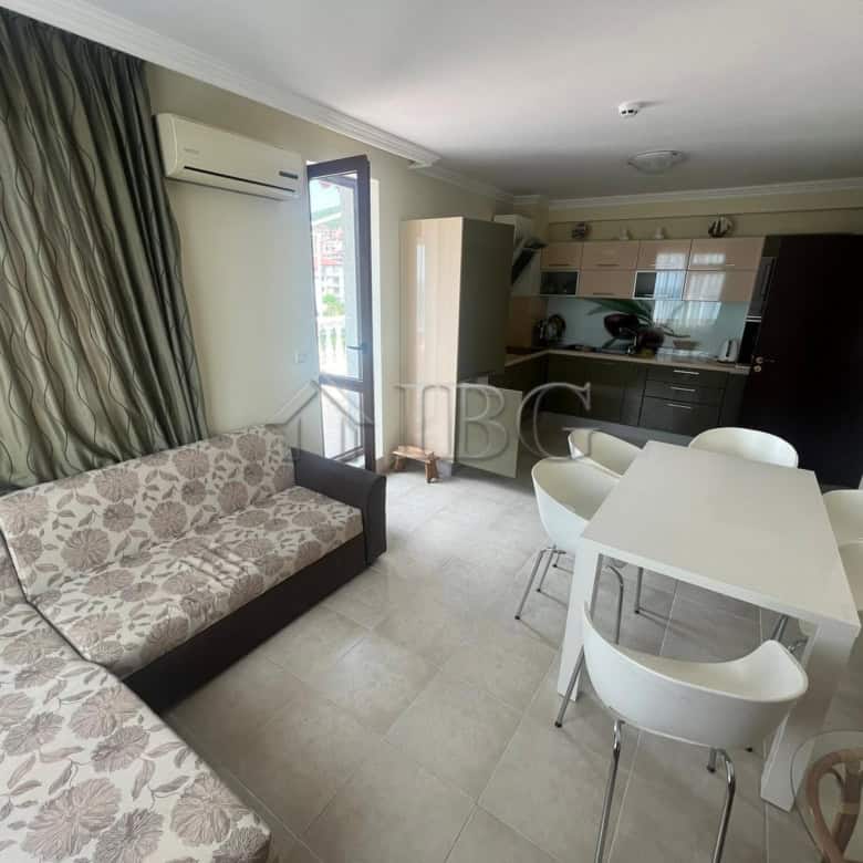 Bright living room with sea view, sofa, dining area, and open kitchen in Sveti Vlas apartment.