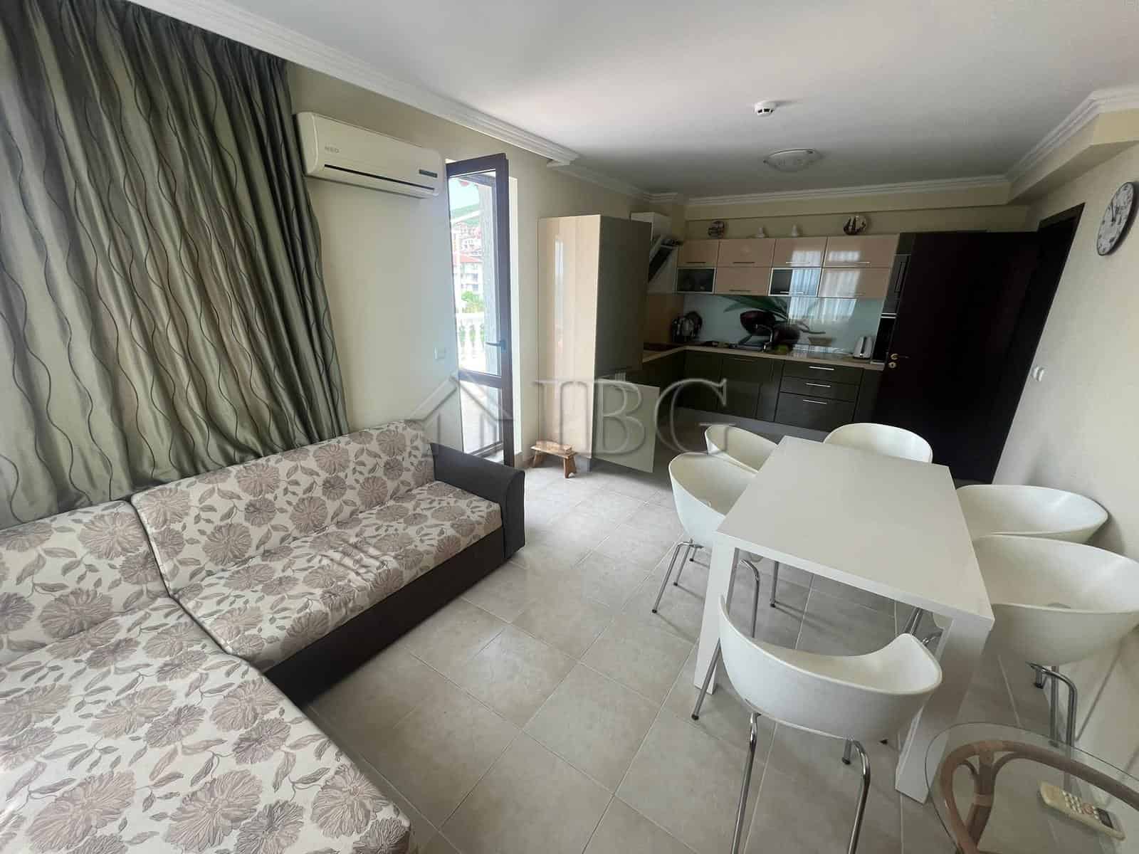 Bright living room with sea view, sofa, dining area, and open kitchen in Sveti Vlas apartment.