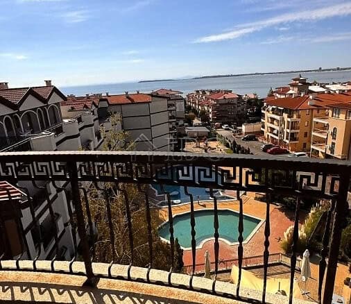 View of sea, pool, and surrounding buildings from balcony in Sveti Vlas.