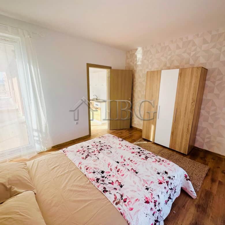 Comfortable bedroom with a large bed and floral bedding in a sunny apartment.