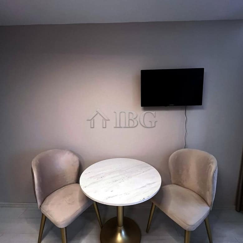 Furnished studio with balcony, modern decor, and a flat-screen TV in a new complex at Sunny Beach.